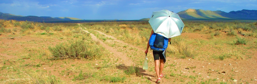 When it's hot and dry like New Mexico, you'll need to carry extra water, like I'm doing here. Since you sweat less with an umbrella, you'll need less water than without an umbrella